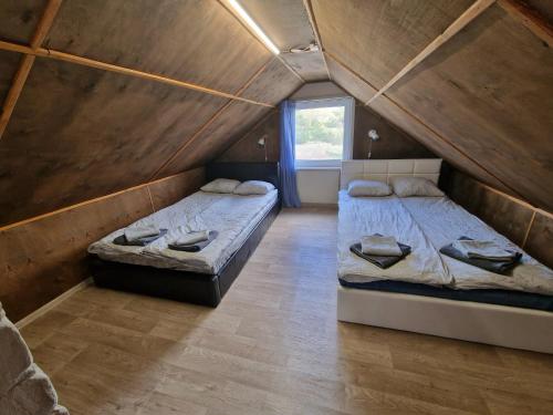 two beds in a room with a attic at Paju Majutus! in Ohtja