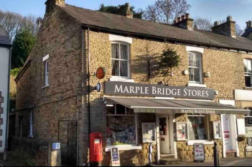 an old brick building with a market bridge stores at Hollins Cottage. Central location, Marple Bridge in Marple