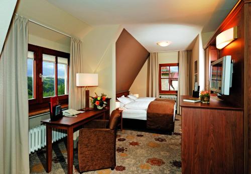 a hotel room with a bed and a desk at Burghotel in Rothenburg ob der Tauber