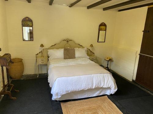 Schlafzimmer mit einem Bett mit weißer Bettwäsche und Kissen in der Unterkunft Southfields Farm in Nottingham