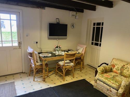 sala de estar con mesa, sillas y TV en Southfields Farm en Nottingham