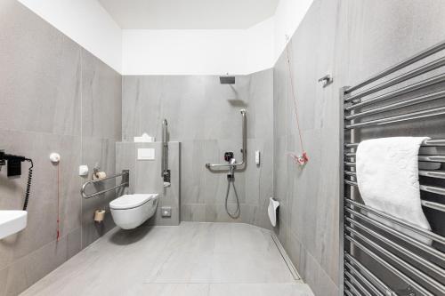 a bathroom with a shower with a toilet and a sink at Theresian Hotel in Olomouc