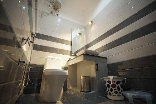 a bathroom with a white toilet and a sink at Dreamy Desert Hotel in Haldwāni