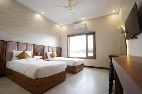 a bedroom with two beds and a large window at Dreamy Desert Hotel in Haldwāni