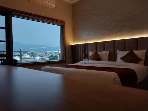 a hotel room with two beds and a large window at Dreamy Desert Hotel in Haldwāni
