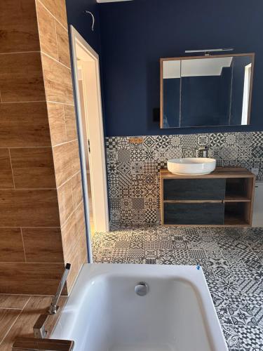 a bathroom with a white tub and a sink at Domy wakacyjne WELLE in Kołczewo