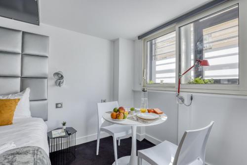 une chambre avec un lit et une table avec des fruits dessus dans l'établissement Branded New and Comfy Studio - Heart of Paris 3, à Paris