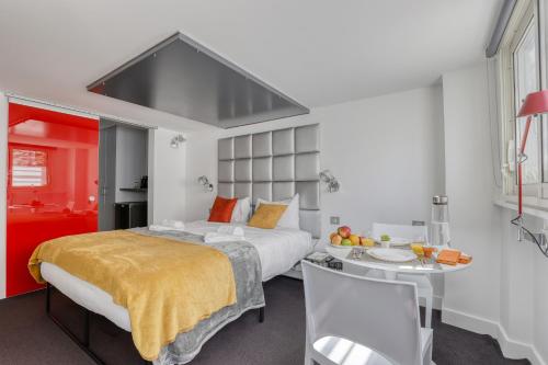 une chambre avec un grand lit et une table et des chaises dans l'établissement Branded New and Comfy Studio - Heart of Paris 3, à Paris