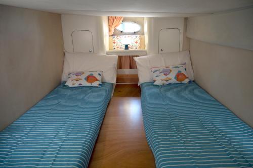 Habitación pequeña con 2 camas en Taranto in barca Boat and Breakfast, en Taranto
