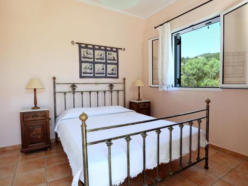 a bedroom with a bed and a window at VK Villas in Apolpaina