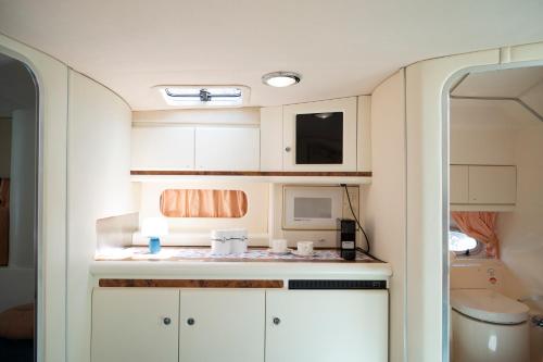 eine Küche mit weißen Schränken und einer Mikrowelle in der Unterkunft Taranto in barca Boat and Breakfast in Taranto
