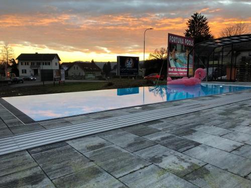 an empty swimming pool with a sunset in the background at Ferienwohnung Sissy in Bad Gleichenberg