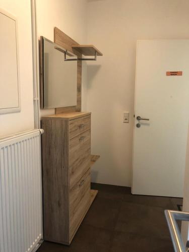ein Badezimmer mit einer Kommode mit einem Spiegel und einer Tür in der Unterkunft Ferienwohnung Sissy in Bad Gleichenberg
