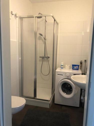 a bathroom with a shower and a washing machine at Ferienwohnung Sissy in Bad Gleichenberg