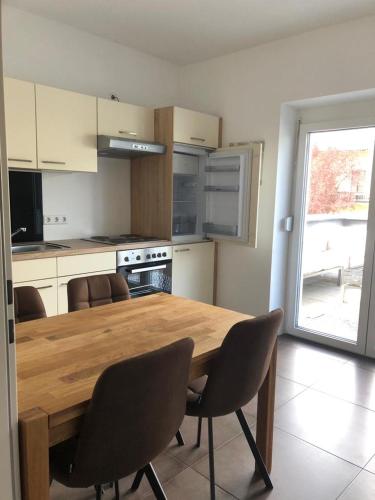 une cuisine avec une table en bois entourée de chaises. dans l'établissement Ferienwohnung Sissy, à Bad Gleichenberg