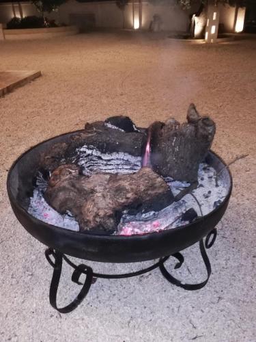 a fire pit with a piece of meat in it at Ciao b&b in Selva di Fasano