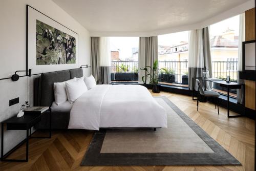 ein Schlafzimmer mit einem weißen Bett und einem großen Fenster in der Unterkunft Juno Hotel Sofia, a Member of Design Hotels in Sofia