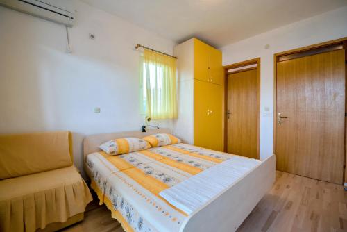 Apartmani Topolovec في Luka: غرفة نوم صغيرة مع سرير وأريكة