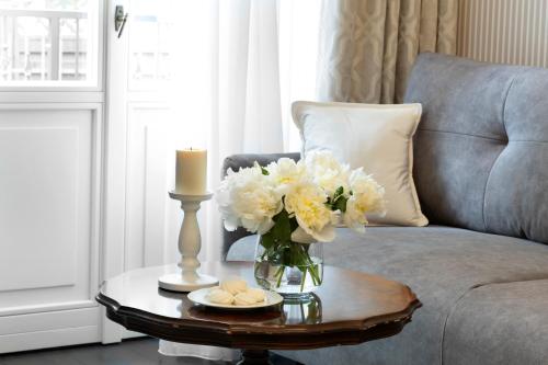 a living room with a vase of flowers on a table at Willa Szwarc by Elite Apartments in Sopot