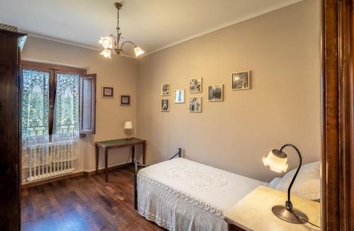 Schlafzimmer mit einem Bett, einem Tisch und einem Fenster in der Unterkunft Panoramic apartment in Massa