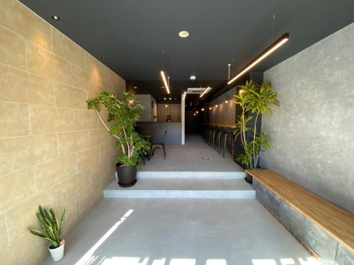 a hallway with stairs and potted plants in a building at Tiz wan hotel in Sumoto