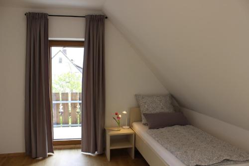 a small bedroom with a bed and a window at Fränkische Seenliebe in Gunzenhausen