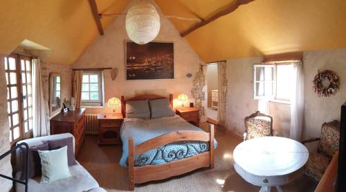 1 dormitorio con 1 cama y 1 mesa en una habitación en Moulin de la Bretonnière - Omaha Beach Dday, en Aignerville