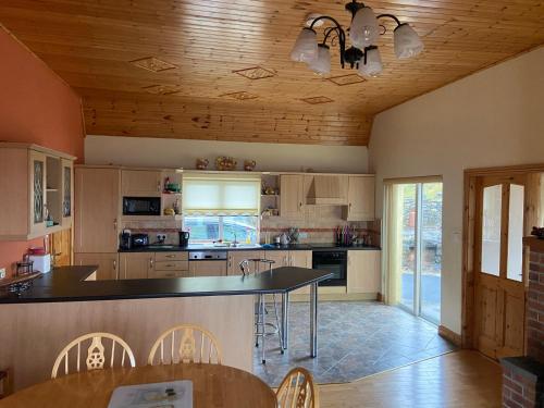 a kitchen with a counter and a table and chairs at The Cliffs of Moher House, Doolin in Droíchead an Chláir