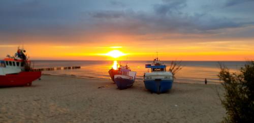a group of boats on the beach at sunset at UniBal - pokoje gościnne in Unieście