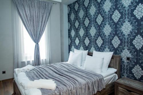 a bedroom with a bed with a blue wall at VN Hotel Vanadzor in Vanadzor