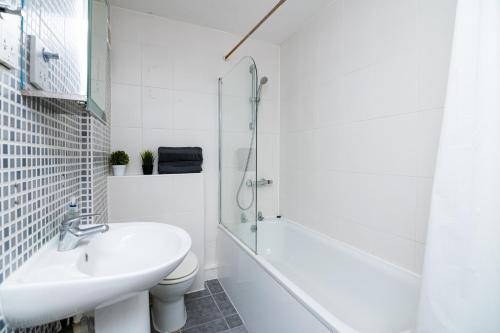 a bathroom with a sink and a toilet and a shower at Charming GEM II 2BD 2BA Retreat in London