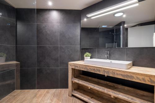 a bathroom with a sink and a mirror at Bungalowpark Het Verscholen Dorp in Harderwijk