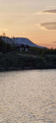 a house on the shore of a body of water at Svart Lodge in Akureyri