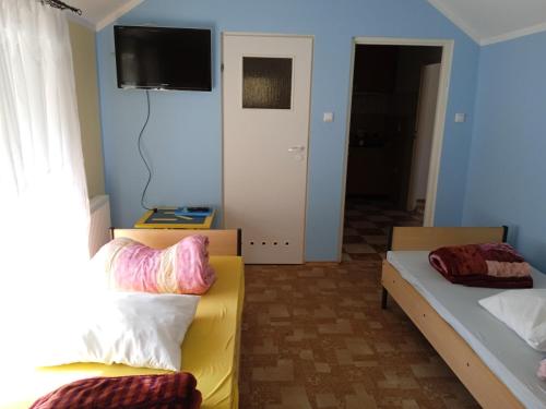 - une chambre avec 2 lits et une télévision murale dans l'établissement Kwatera do wynajęcia, à Gołdap