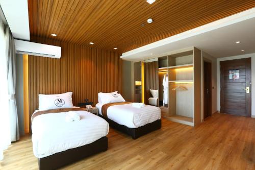 a hotel room with two beds in a room at Montana Hotel Songkhla in Songkhla