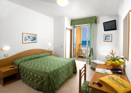 a hotel room with a bed and a table and a desk at Hotel Belvedere in Misano Adriatico
