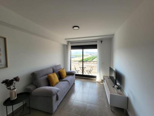 een woonkamer met een bank en een televisie bij Apartamento Margalló con Garaje in Xilxes