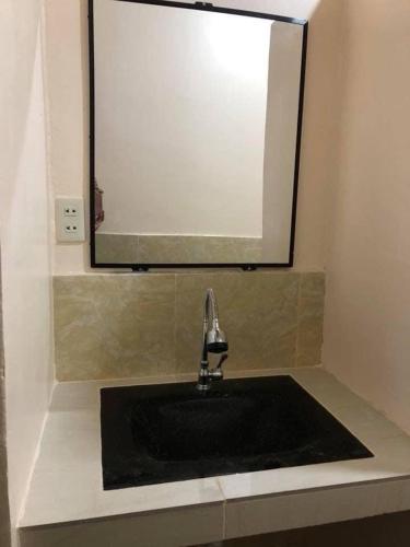 a bathroom with a black sink and a mirror at Caminres Homestay in Bug-ong