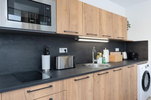 a kitchen with a sink and a microwave at Arbio I Central Apartments Koblenz in Koblenz