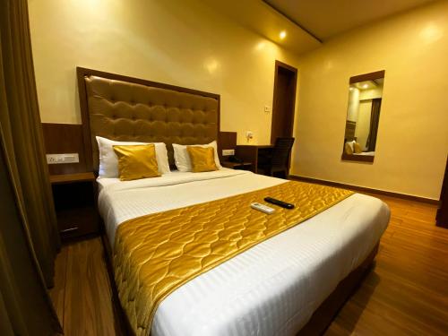 Cette chambre comprend un grand lit avec des draps jaunes. dans l'établissement Hotel Pearl's BKC Inn- Near Trade Centre, Visa Consulate, à Mumbai