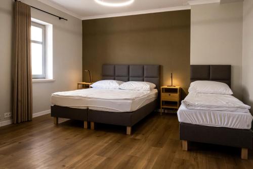 two twin beds in a room with wooden floors at ORKANA House in Olsztyn