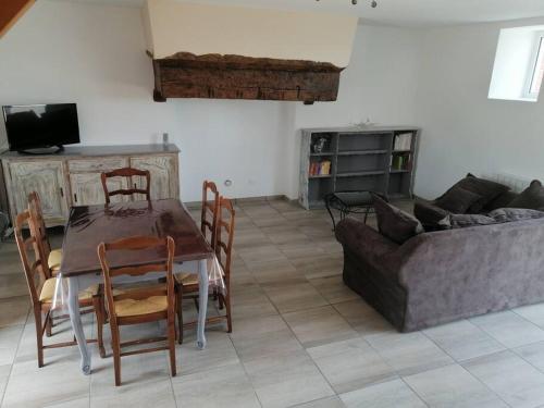 a living room with a table and a couch at Maison de campagne in Saint-Jouan-de-lʼIsle