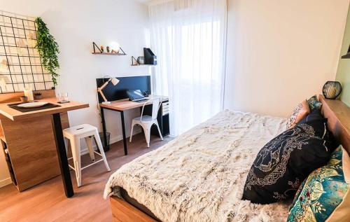 a bedroom with a bed and a desk with a computer at UXCO Uppehalls in Le Petit-Quevilly