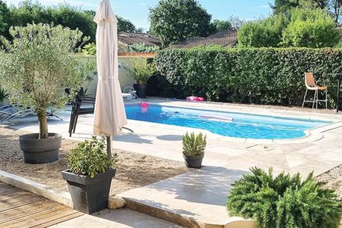 - une piscine avec un parasol dans l'établissement Villa tout confort, piscine - Au pied du VENTOUX, à Saint-Didier