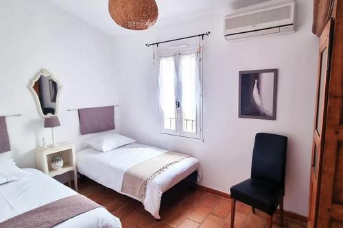 une chambre avec deux lits et une chaise dans l'établissement Villa tout confort, piscine - Au pied du VENTOUX, à Saint-Didier