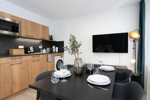 a dining room with a black table and chairs at Arbio I Central Apartments Koblenz in Koblenz