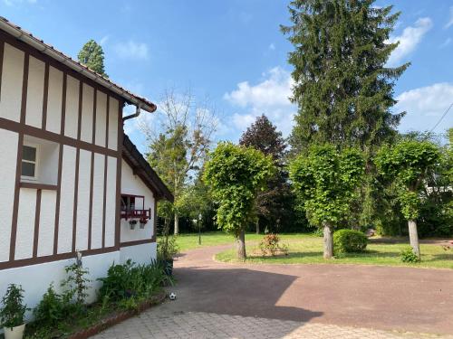 uma casa com uma árvore ao lado de uma entrada em Studio épicéa avec jardin dans charmante propriété em Méry-sur-Oise