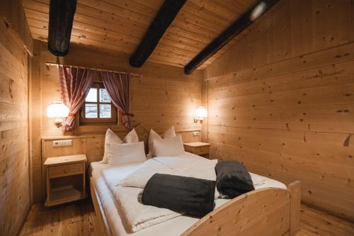 um quarto com uma cama num chalé de madeira em Lechnerhütte Fane Alm em Valles
