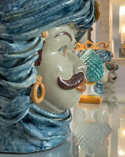 a glass statue of a woman on a table at Relais Antica Badia - San Maurizio 1619 in Ragusa