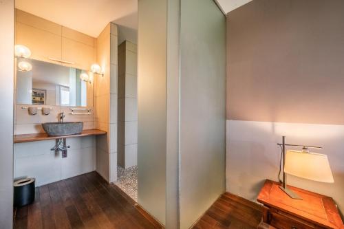 La salle de bains est pourvue d'un lavabo et d'un miroir. dans l'établissement Gîte Le Jorat - Studio, à Bogève